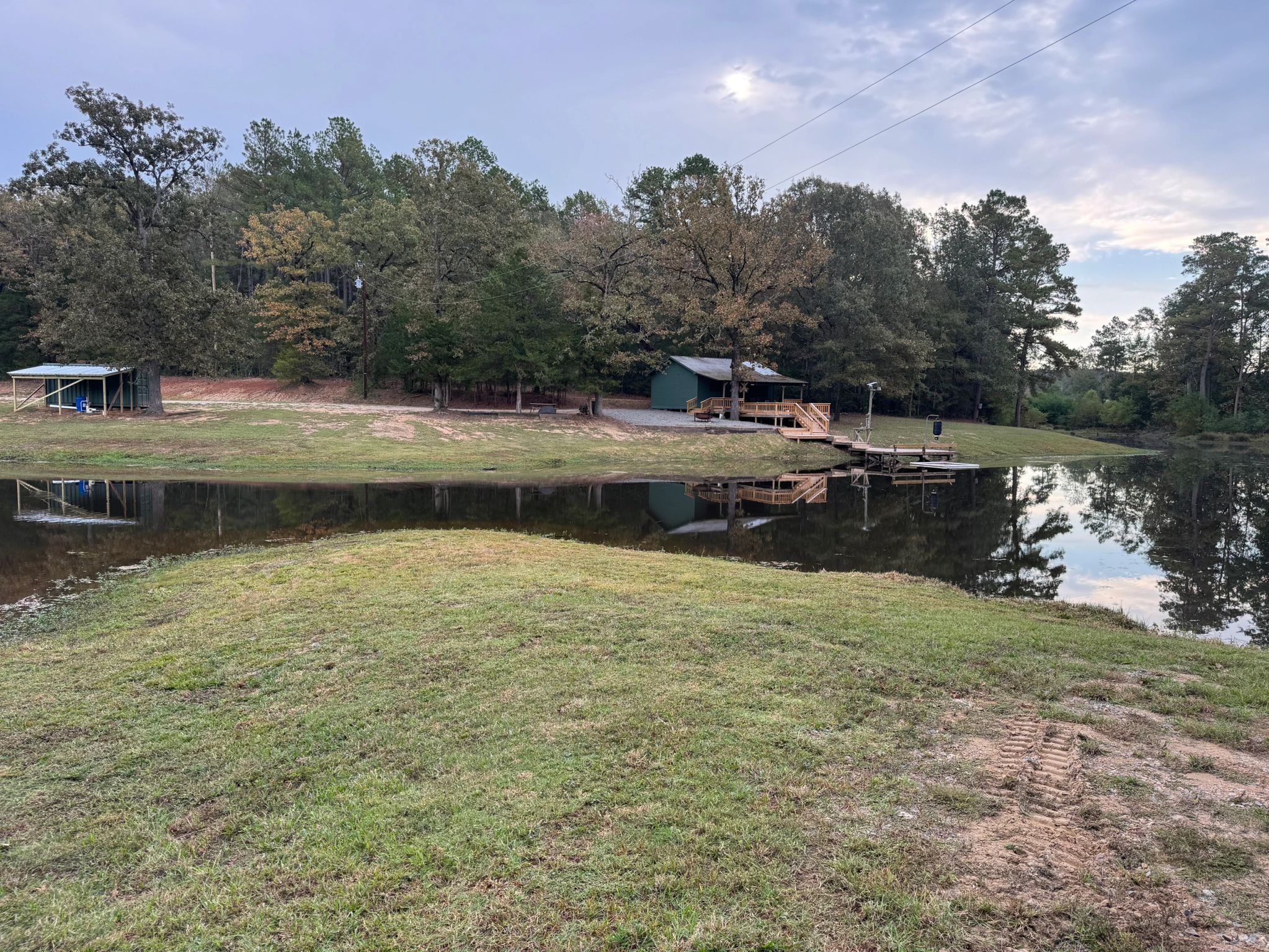 Pond, cabin, and dock at Our Pocket Life on an overcast day